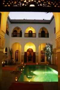 a large building with a swimming pool in a courtyard at Riad Shama Suites & Spa in Marrakech