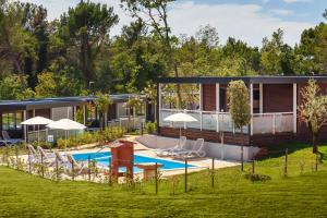 una casa con piscina en un patio en Premium Camping Homes Santa Marina, Lanterna, en Poreč