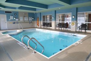 ein großer Pool mit Stühlen in einem Gebäude in der Unterkunft Holiday Inn Express Brampton, an IHG Hotel in Brampton