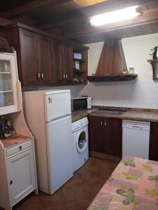 La cuisine est équipée d'un réfrigérateur blanc et d'un lave-vaisselle. dans l'établissement CASA RURAL LA MONTESINA, à Cangas de Onís