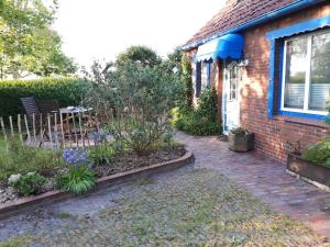 een stenen huis met een tuin met paarse bloemen bij Villa Friesenkät in Wangerland