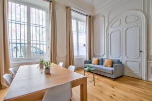 uma sala de estar com uma mesa e um sofá em 21Royale em Lyon