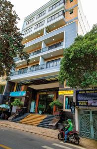 a man riding a motorcycle in front of a building at Căn Hộ dịch vụ cao cấp Sân Bay Tân Sơn Nhất in Ho Chi Minh City