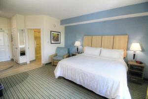 a hotel room with a large bed and a chair at Candlewood Suites - Memphis East by IHG in Memphis