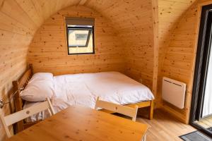 a room with a bed and a table in a cabin at Camping Pods, Dovercourt Holiday Park in Harwich