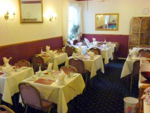 a restaurant with white tables and chairs with white table cloth at The Berkswell in Blackpool