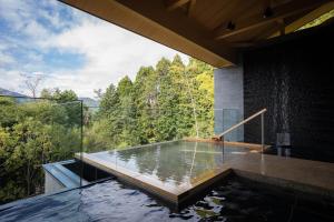 a swimming pool in a house with a view of the forest at THE HIRAMATSU HOTELS & RESORTS SENGOKUHARA HAKONE in Hakone