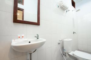 a white bathroom with a sink and a toilet at OYO 2068 Abhaya Mudra Homestay in Magelang