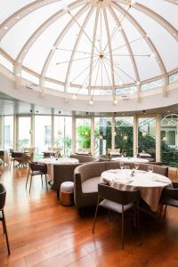een restaurant met tafels en stoelen en een glazen koepelplafond bij Holiday Inn Milan Garibaldi Station, an IHG Hotel in Milaan
