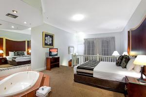 a hotel room with a bed and a bath tub at Mercure Maitland Monte Pio in Maitland