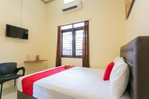 SumenepにあるRedDoorz @ Hotel Surabaya Sumenepのベッドルーム1室(ベッド1台、窓、椅子付)