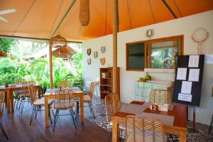 吉利特拉旺安的住宿－Gili Tenda，一间带桌椅的用餐室和窗户。