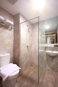 y baño con ducha, aseo y lavamanos. en Cordela Inn Bengkulu en Bengkulu