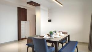 a dining room with a table and blue chairs at Waterfront 3BR 3Bath in Sibu