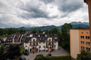 an aerial view of a house with mountains in the background at Apart-Center Przy Krupówkach in Zakopane