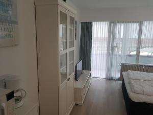 クックスハーフェンにあるGemütliches Apartment direkt am Strandのベッドルーム(ベッド1台、デスク、テレビ付)