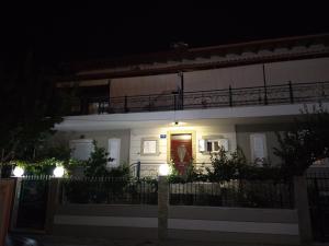 a white house with a red door at night at SeaSide Apartment Rio in Rio