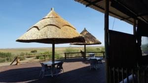 due tavoli e sedie e ombrelloni su una terrazza di Mwandi View a Kavimba