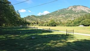 a group of benches in a field with a mountain at Camping White Rock in Castellane