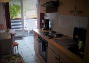 a kitchen with a stove top oven next to a window at Ferienhaus Gossel in Bad Wildungen