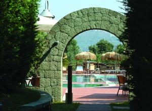 um arco de pedra que leva a uma piscina em Montespina Park Hotel em Nápoles