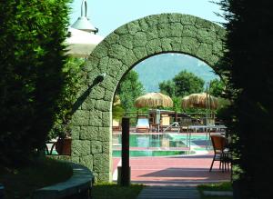 einen steinernen Torbogen, der zu einem Pool führt in der Unterkunft Montespina Park Hotel in Neapel