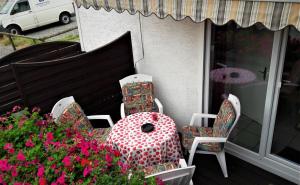 a table and chairs on a porch with flowers at Ferienhaus Gossel in Bad Wildungen