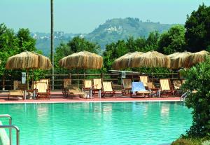 a group of chairs and umbrellas next to a swimming pool at Montespina Park Hotel in Naples