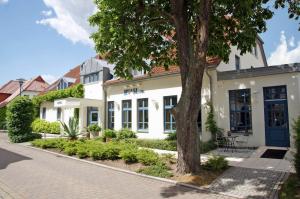 グライフスヴァルトにあるRyck-Hotel Garniの前に木がある白い建物