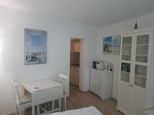 クックスハーフェンにあるGemütliches Apartment direkt am Strandの白い部屋(テーブル、キッチン付)