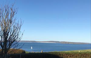 a sailboat on a large body of water at Tornaroan Cottage in Ballycastle