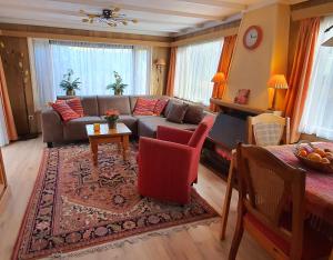 a living room with a couch and a table at Knus chalet midden in de natuur en de rust. in Wageningen