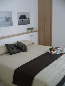Una cama con una bandeja de comida encima. en Le Stanze Del Sole, en Ragusa