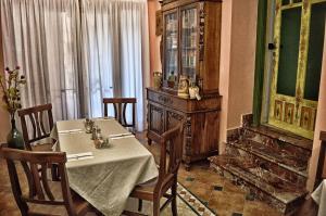 a dining room with a table and chairs and a cabinet at Hotel Victoria in Taormina