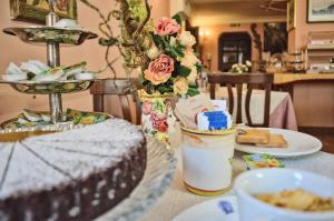 a table with a cake and a plate of food at Hotel Victoria in Taormina