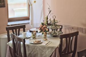 a table with chairs and a table with a flower arrangement on it at Hotel Victoria in Taormina