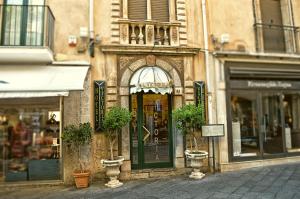 a building with a door with two potted plants on it at Hotel Victoria in Taormina
