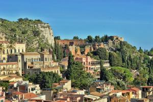 a town on a hill with houses and trees at Hotel Victoria in Taormina