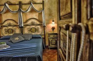 a bedroom with a bed with a blue comforter at Hotel Victoria in Taormina