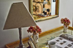 a lamp sitting on a table next to a mirror at Hotel Victoria in Taormina