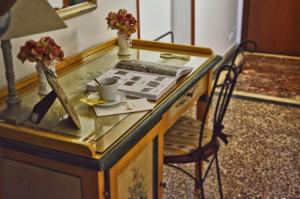 a desk with a glass top with a cup and a chair at Hotel Victoria in Taormina