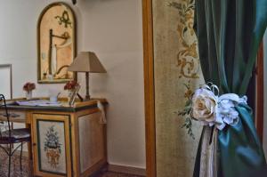 a room with a desk and a dresser with a flower at Hotel Victoria in Taormina