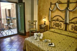 a bedroom with a large bed and a balcony at Hotel Victoria in Taormina