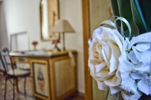 a white flower in a vase in a room at Hotel Victoria in Taormina