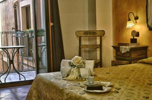 a bedroom with a bed with a table and a balcony at Hotel Victoria in Taormina