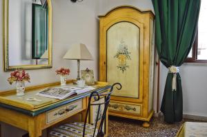 a room with a desk and a mirror at Hotel Victoria in Taormina