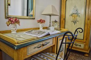 a desk with a lamp and a table with a chair at Hotel Victoria in Taormina