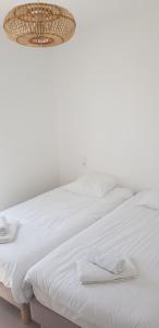 ein weißes Bett mit zwei Handtüchern darauf in der Unterkunft Les TERRASSES de BELLA VISTA(b) Belle maison bord de mer in Saint-Vincent-sur-Jard