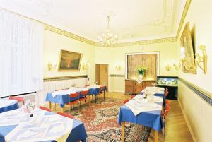 a dining room with blue tables and chairs at Hotel Gunia in Berlin