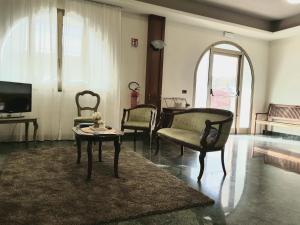 uma sala de estar com cadeiras, uma mesa e uma televisão em Hotel Rio Rè em San Marino